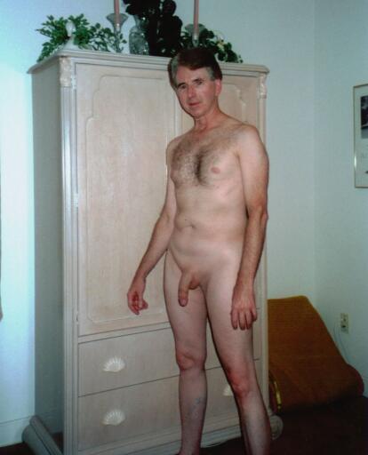 Andrew standing nude by the armoire in the master bedroom fully shaved and totally exposed for all to see.