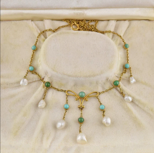 Exquisite Art Nouveau necklace with green turquoise gemstones and natural pearl drops exude femininity in this 14K gold antique treasure. Dangling gold chains are punctuated with natural creamy white pearls. The center element has a flowing Nouveau design with pearls and turquoise. A fine 14K gold chain completes the piece. The perfect heirloom treasure!

Materials: 14 karat gold
Gemstone: Genuine turquoise, Natural pearls
Weight: 7 grams
Hallmarks: 14K
Condition: Very good with all stones present and having a lovely coloring. An elegant and very collectible antique piece of jewelry!

https://boylerpf.com/products/art-nouveau-14k-gold-turquoise-natural-pearl-necklace

#VintageandAntiqueJewelryOnline #VictorianAntiqueRings #AntiqueJewelry #VintageJewelry #VintageArtDecoJewelry #EstateVintage&Antiquerings #Antiqueedwardianjewelry #Antiqueedwardiannecklace #VictorianJewelry #Vintagegemstonerings #VintageDiamondRings #Vintageengagementrings #Vintagecocktailrings