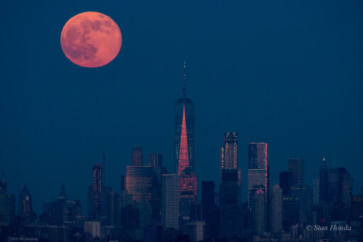 A Full Moon rose as the Sun set on June 9, known to some as a Strawberry Moon. Close to the horizon and taking on the warm color of reflected sunlight filtered through a dense and dusty atmosphere, the fully illuminated lunar disk poses with the skyscrapers along the southern Manhattan skyline in this telephoto snapshot. The picture was taken from Eagle Rock Reservation, a park in West Orange, New Jersey, planet Earth. That's about 13 miles from southern Manhattan and some 240,000 miles from the Moon. Foreground faces of the modern towers of steel and glass share the Moon's warm color by reflecting the last rays of the setting Sun. The tallest, with the shining triangular facet, is New York City's One World Trade Center. Image Credit & Copyright: Stan Honda