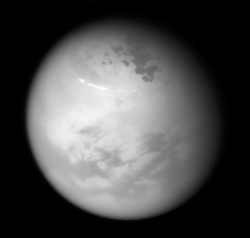 While yesterday's solstice brought summer to planet Earth's northern hemisphere, a northern summer solstice arrived for ringed planet Saturn nearly a month ago on May 24. Following the Saturnian seasons, its large moon Titan was captured in this Cassini spacecraft image from June 9. The near-infrared view finds bright methane clouds drifting through Titan's northern summer skies as seen from a distance of about 507,000 kilometers. Below Titan's clouds, dark hydrocarbon lakes sprawl near the large moon's now illuminated north pole. Image Credit: Cassini Imaging Team, SSI, JPL, ESA, NASA