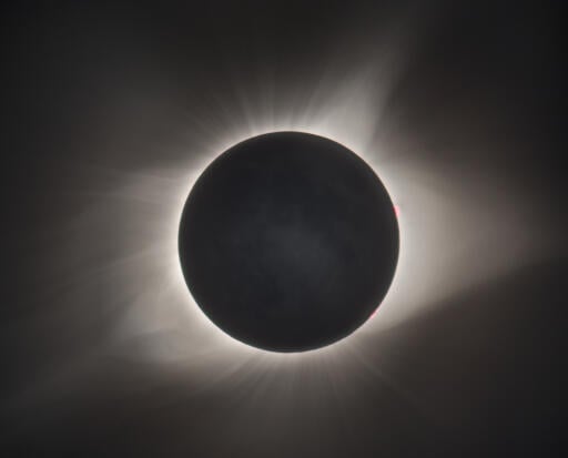 During a total solar eclipse, the Sun's extensive outer atmosphere, or corona, is an inspirational sight. Streamers and shimmering features visible to the eye span a brightness range of over 10,000 to 1, making them notoriously difficult to capture in a single photograph. But this composite of telescopic images covers a wide range of exposure times to reveal the crown of the Sun in all its glory. The aligned and stacked digital frames were taken in clear skies above Stanley, Idaho in the Sawtooth Mountains during the Sun's total eclipse on August 21. A pinkish solar prominence extends just beyond the right edge of the solar disk. Even small details on the dark night side of the New Moon can be made out, illuminated by sunlight reflected from a Full Earth. Image Credit & Copyright: Derek Demeter (Emil Buehler Planetarium).